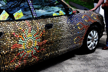 A car covered in metal bottle caps with a sun design.